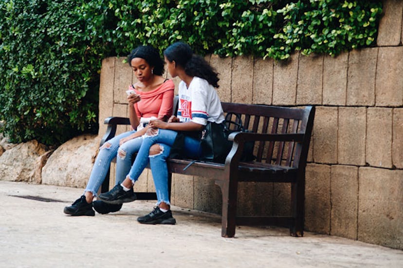 Two women sitting on a bench talking about divorce signs in a marriage