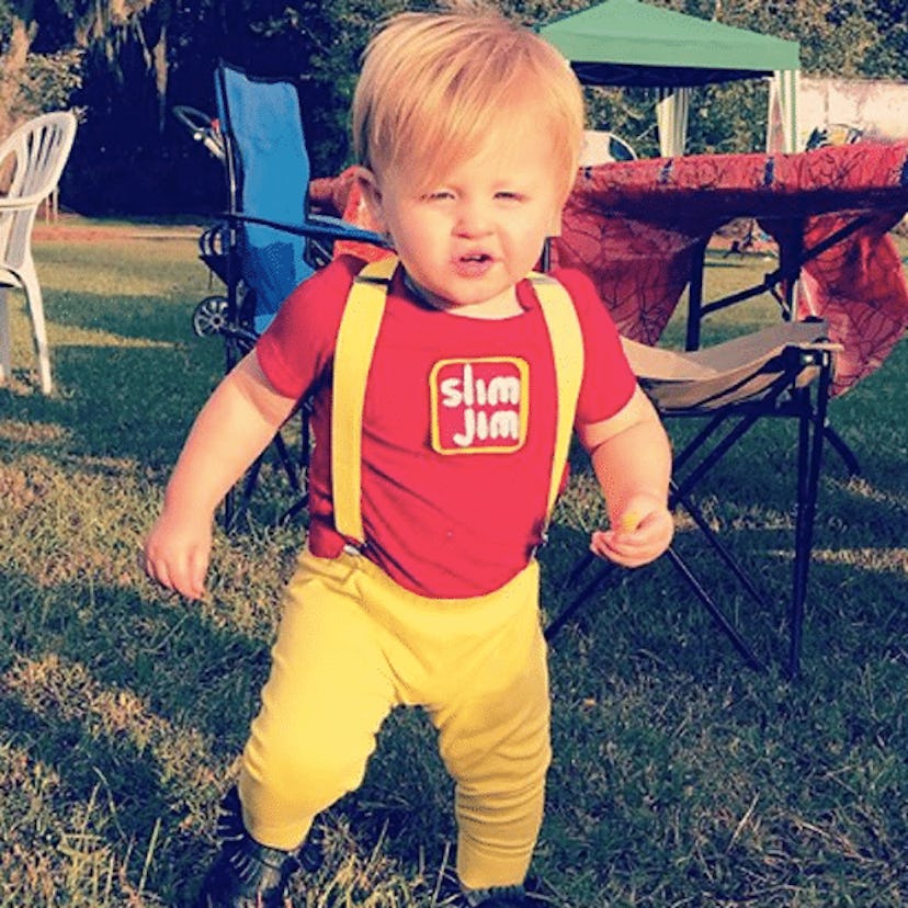 A blonde toddler running in a red Slim Jim baby costume    