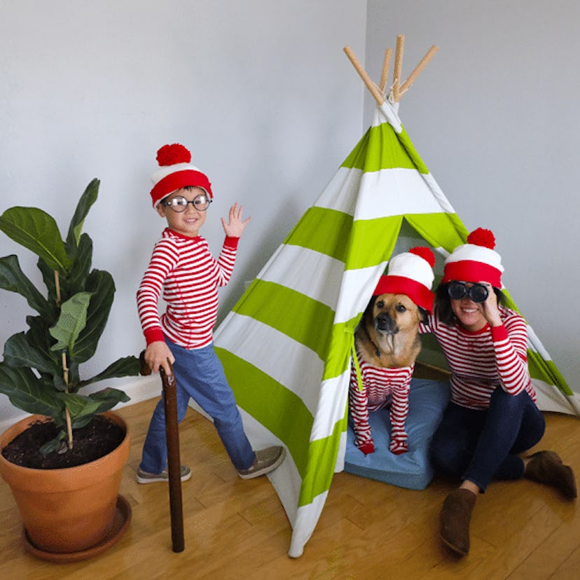 A mother, a son, and a dog wearing a red and white Where’s Waldo Halloween costumes 