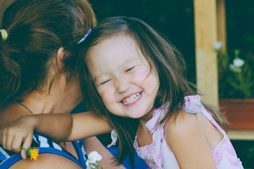 Little girl smiling while her grandma holds her 