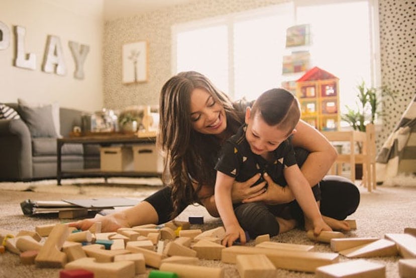 Stephanie Hanharan and her her son playing on the floor in her living room with wooden blocks