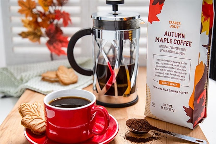 New at Trader Joe's, red mug of coffee beside cookie, coffee spoon and coffee pack