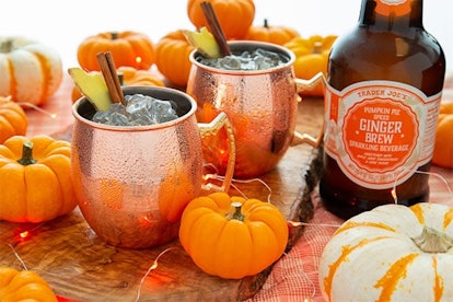 New at Trader Joe's, brew bottle beside two cups and surrounded by lots of mini pumpkins