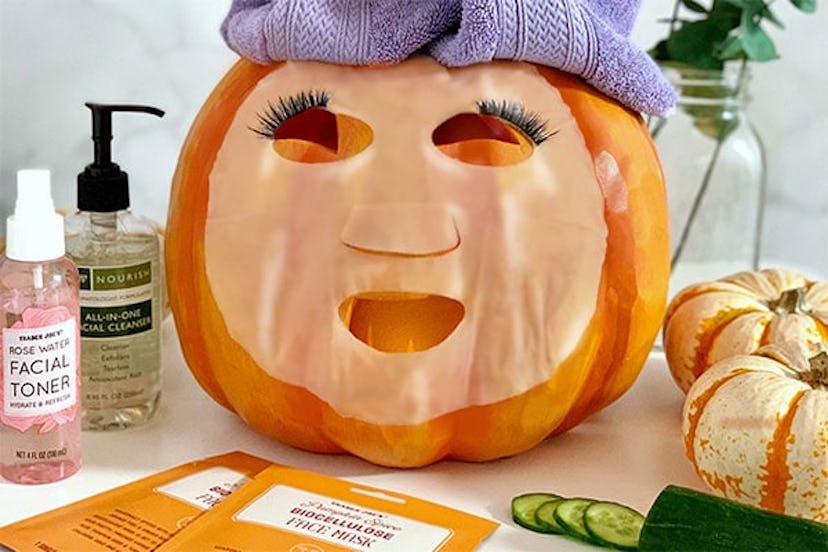 New at Trader Joe's; large pumpkin wearing a face mask and head wrap beside skincare products