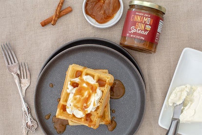 New at Trader Joe's; waffles topped with cream and spread beside spread jar, forks and bowl of cream