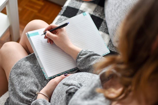 Pregnant woman writing names for her baby