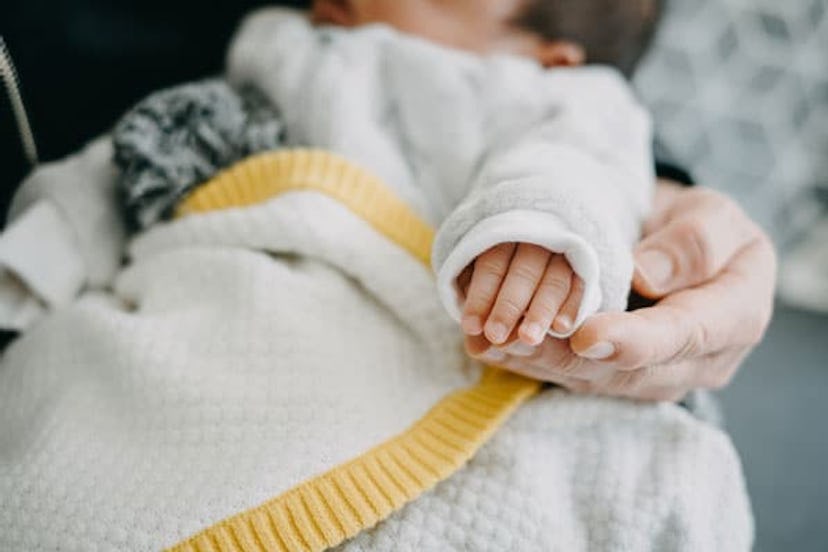 A baby sleeping on a lap of a doting and loving mom