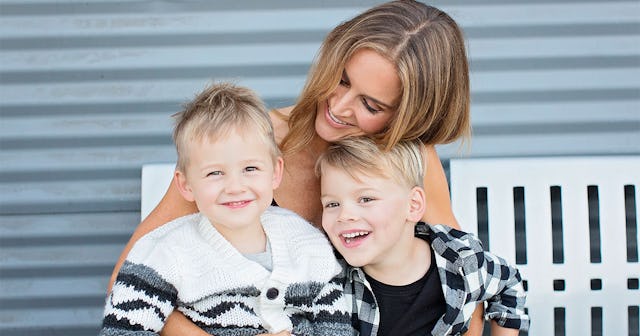 Mom holding her two sons while sitting on the bench