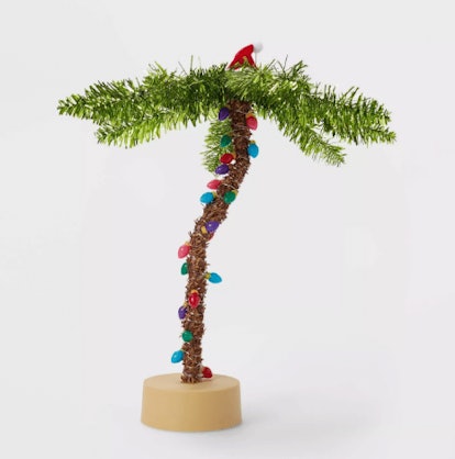 Small palm tree made of pine with Christmas lights on.