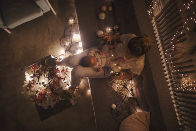 Mother and a newborn baby lying in bed in a Christmasy mood