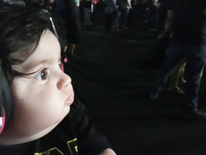 Maxwell at the rock concert looking at the bright lights coming from the stage. He is wearing pink i...