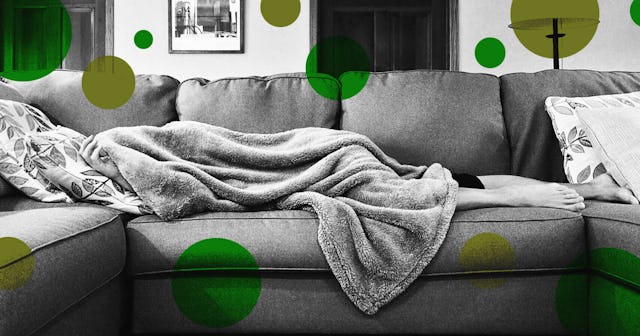 A person lying on a couch and covering everything except the feet with a blanket