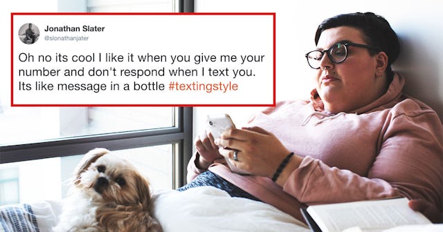 A person in a pink hoodie is texting on her phone while lying in bed next to their dog