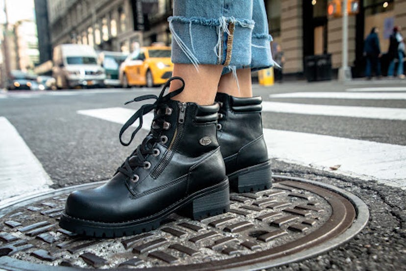 Woman standing on manhole, modeling black chunky boots