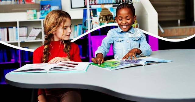 Two girls smiling in a classroom, and one of them is blind