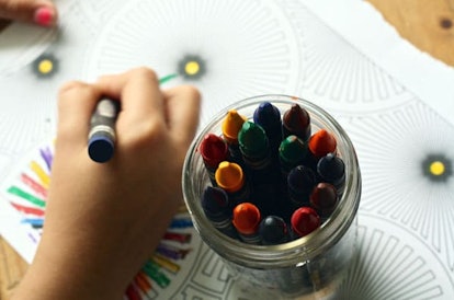 A child in daycare coloring the colorbook with crayons 