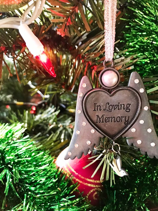 A heart-shaped Christmas ornament with wings that has "in loving memory" engraved on it 
