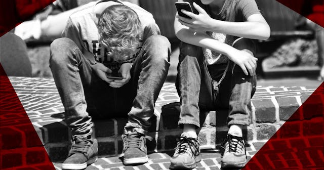 Two boys sitting on the street and surfing on the Internet