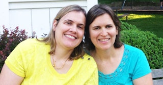 Julie Raeburn in a turquoise shirt sitting next to her sister in a yellow shirt