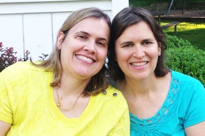 Julie Raeburn in a turquoise shirt sitting next to her sister in a yellow shirt