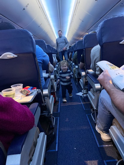 A toddler running happily in an airplane