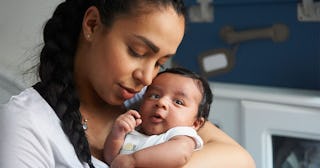 Why I Said No To Visitors For 2 Weeks After Giving Birth: Mother cradling newborn baby in nursery