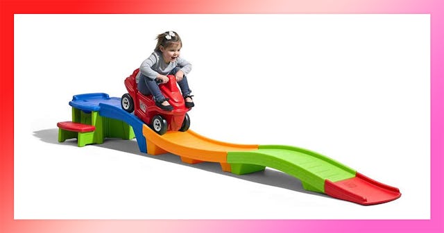 A smiling girl riding the Step2 Up & Down Roller Coaster and Car Set