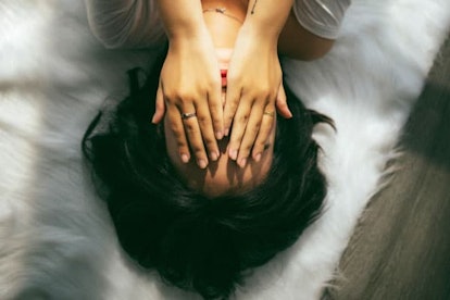 woman laying down covering eyes