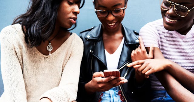 Get Yourself A Group Text: Three friends sitting side by side looking at cell phone