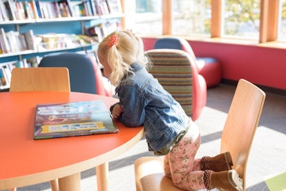 It’s Time To Say Bye-Bye To Library Fines: Little preschool aged girl with blond pigtails at the lib...