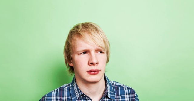 Pains, Stings, And Teenage Boys: confused looking teen boy on green background