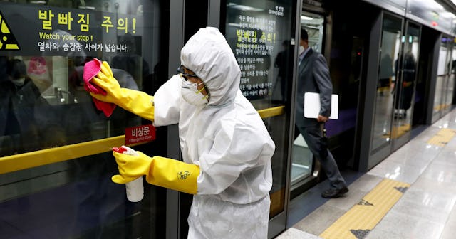 A disinfection professional wearing protective gear spray anti-septic solution against the coronavir...