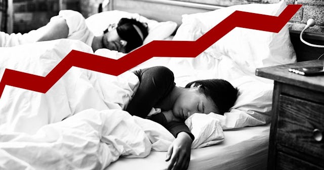 Woman asleep with hand on mattress and man wearing eye mas