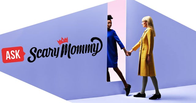 Two women holding hands, walking threw rectangular opening in coloured wall