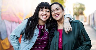 Two Women Leaning Together, Smiling and Happy