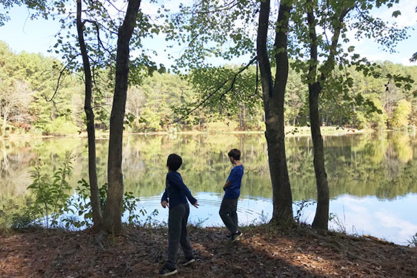two kids by water in the woods