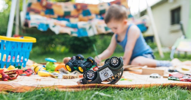 Child playing on a blanket on the grass
