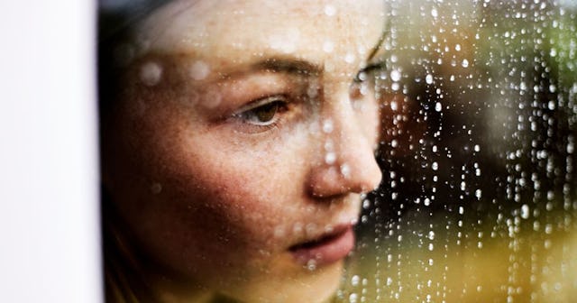 Close-up of pensive young woman looking out of window