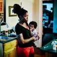 I am Unapologetically One and Done: Mother holding infant in kitchen of home after dinner with famil...
