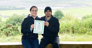 Katarina Garcia and her husband, holding a certificate proving they bought land in Scotland