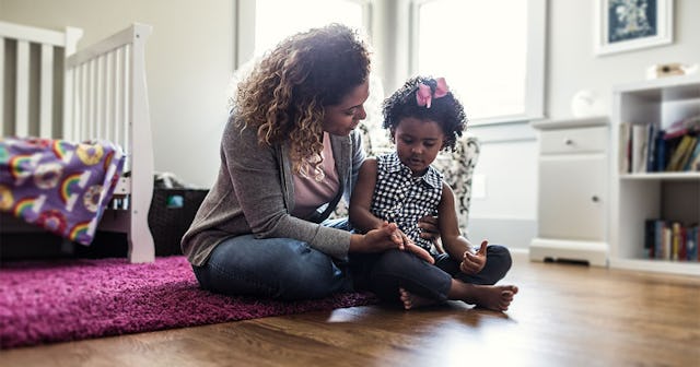 Mother and daughter playing on bedroom floor