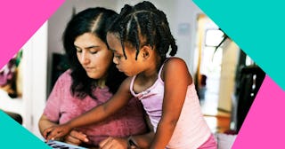 A young and her mother playing with a light box and letters at home together at the dining table.