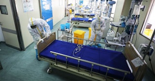 A medical staff member moves a bed at a ward used to be an isolation ward for patients infected by t...