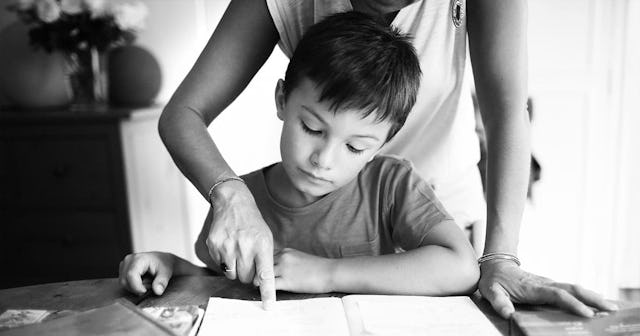boy doing his homework with his mom