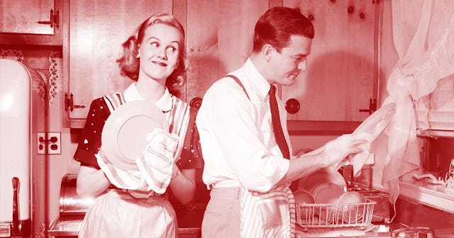 MAN AND WOMAN HUSBAND AND WIFE WASHING DRYING DISHES TOGETHER IN KITCHEN