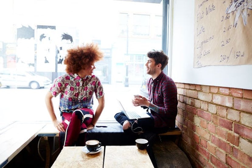 Two friends chatting in coffee shop window