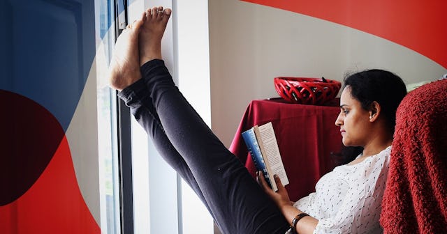 Woman reading book and relaxing at home
