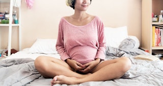 pregnant woman sitting on bed