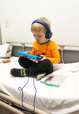 My Son Has Eosinophilic Esophagitis: little boy laying in bed on tablet