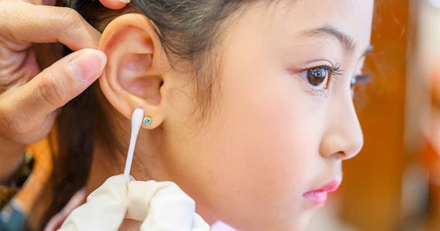girl having ear piercing process